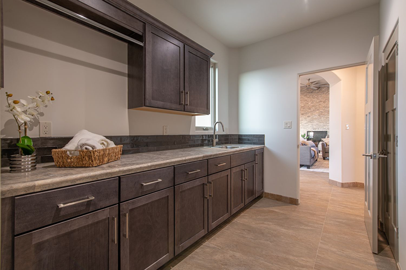 The laundry room provides plenty of counter space and cabinet storage.